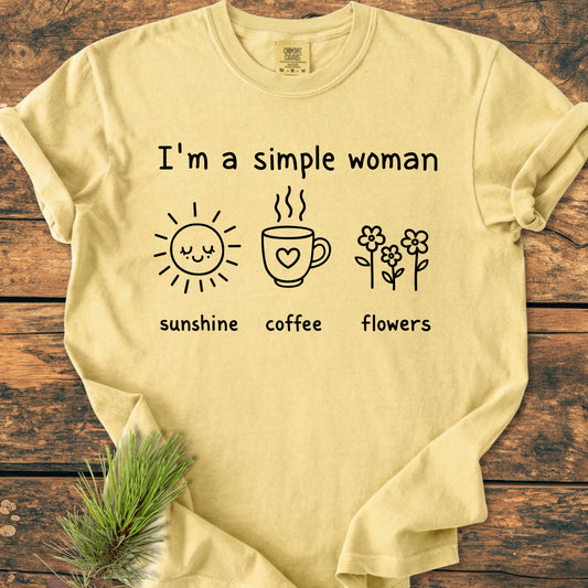 I'm A Simple Woman. Sunshine Coffee Flowers - Vintage Wash Tee featuring a pale-yellow T-shirt with icons of a sun, mug, and flowers on a wooden surface, showcasing its relaxed, garment-dyed design.