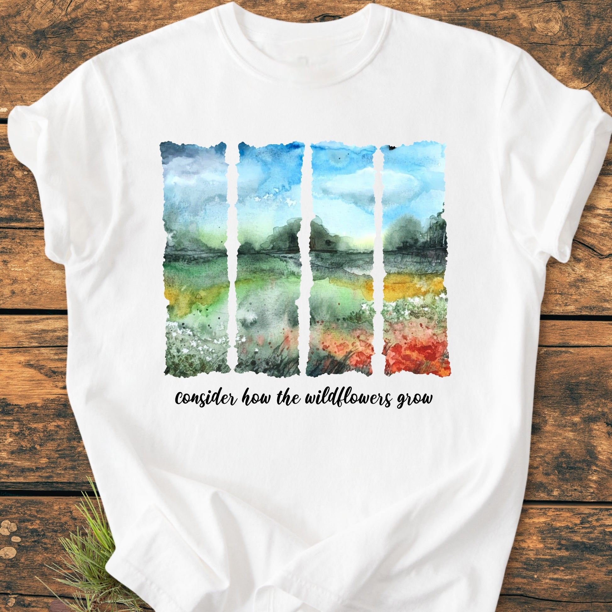 Consider How The Wildflowers Grow - Vintage Heavyweight Tee features a five-panel watercolor landscape with script text on a white T-shirt, highlighting a relaxed fit and durable, ring-spun cotton fabric.
