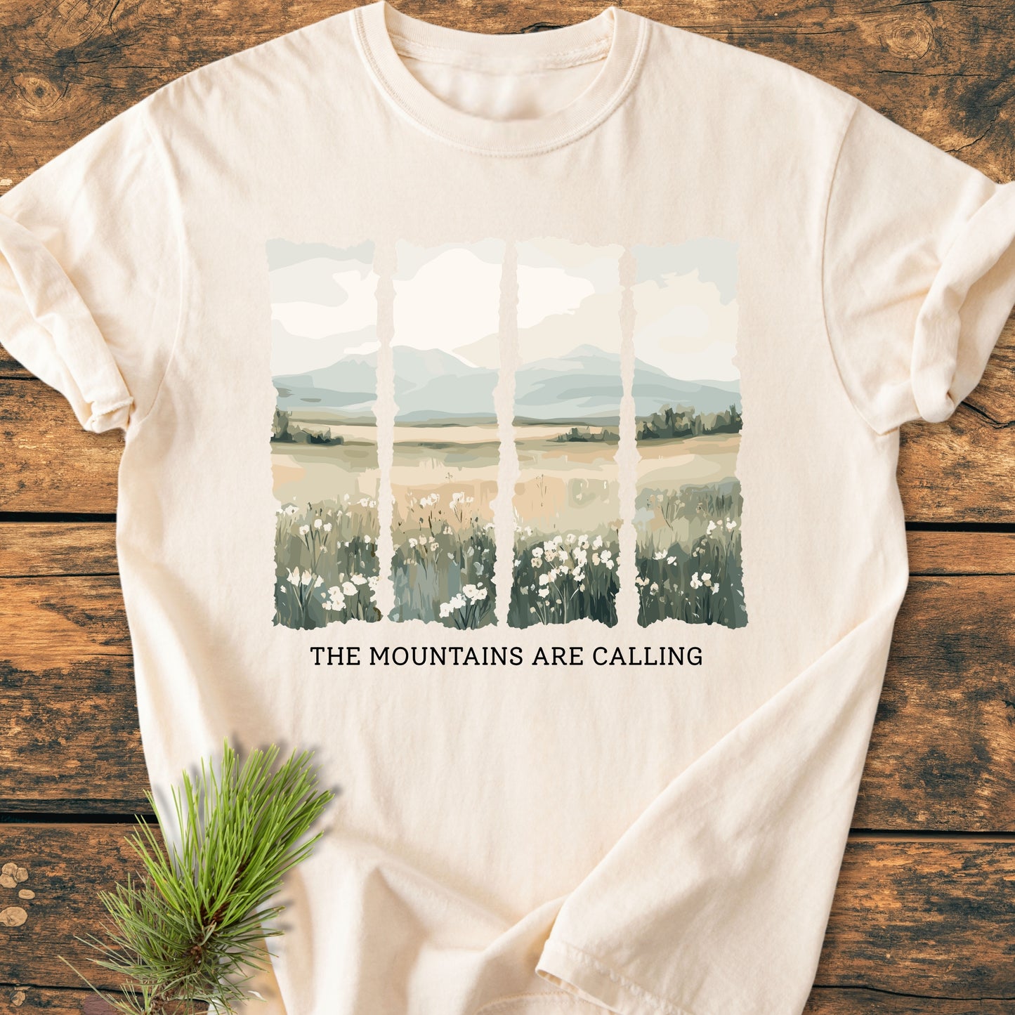 The Mountains Are Calling - Vintage Heavyweight Tee features a stylized landscape graphic on a light-cream T-shirt, highlighting wildflowers, fields, and mountains, with sturdy stitching and relaxed fit for daily comfort.