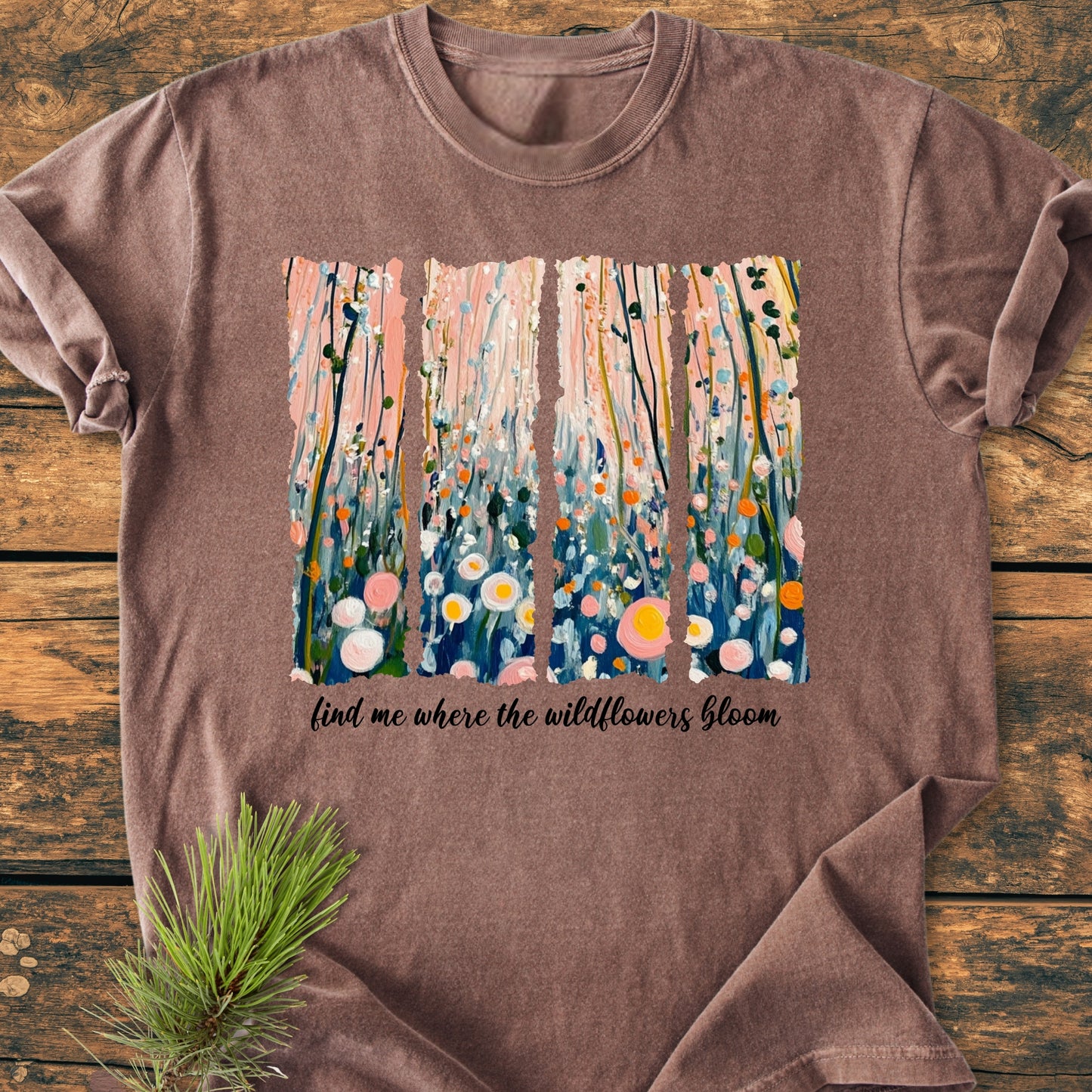 Find Me Where The Wildflowers Bloom - Vintage Heavyweight Tee features a heather-brown color with a pastel floral acrylic painting and slogan on a rustic wooden background, showcasing its relaxed fit and soft-washed fabric.