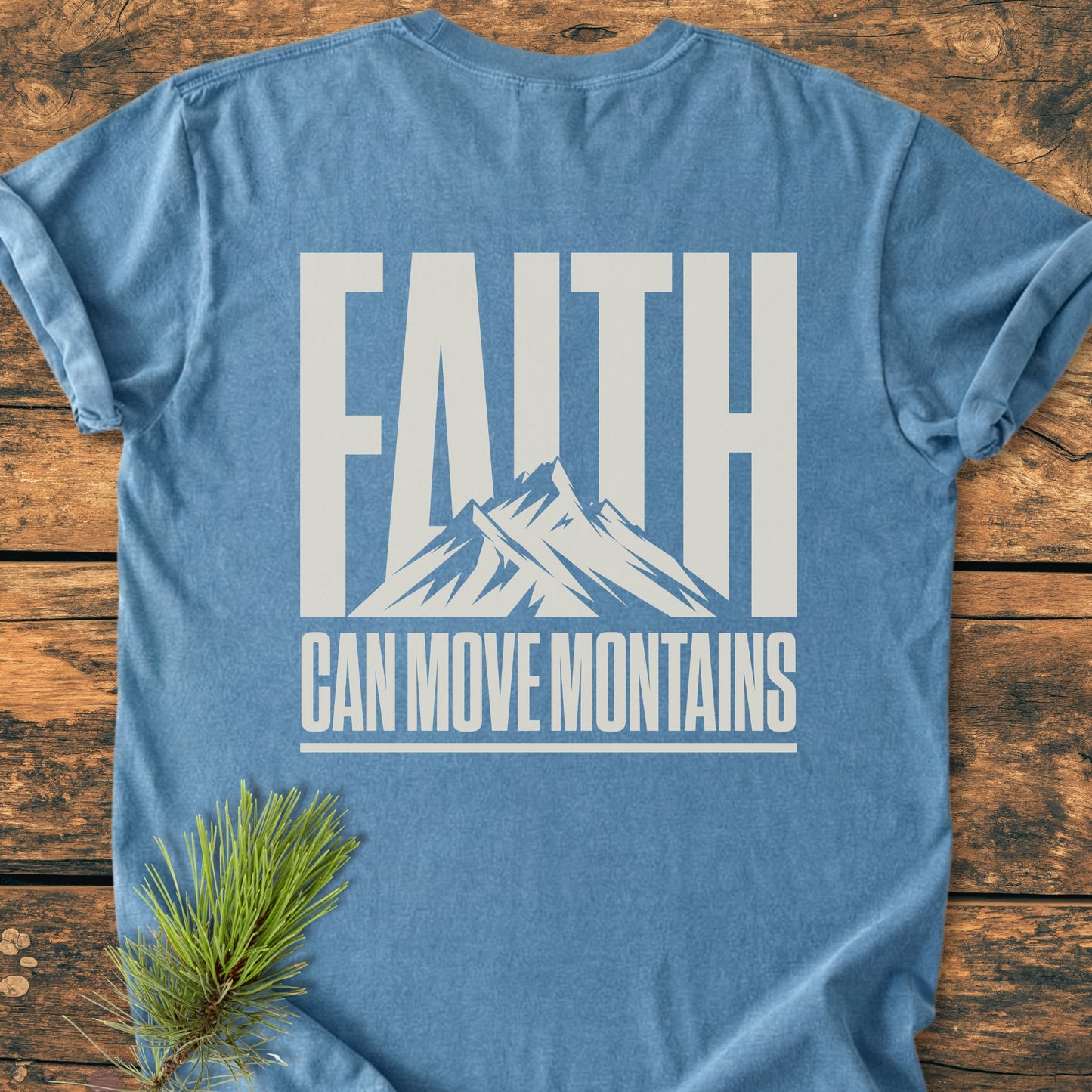 Faith Moves Mountains BACK PRINT - Vintage Wash Tee laid flat with FAITH and mountain graphic in white on back. Features durable, soft-washed, 100% ring-spun cotton with relaxed fit. Pine sprig accents.