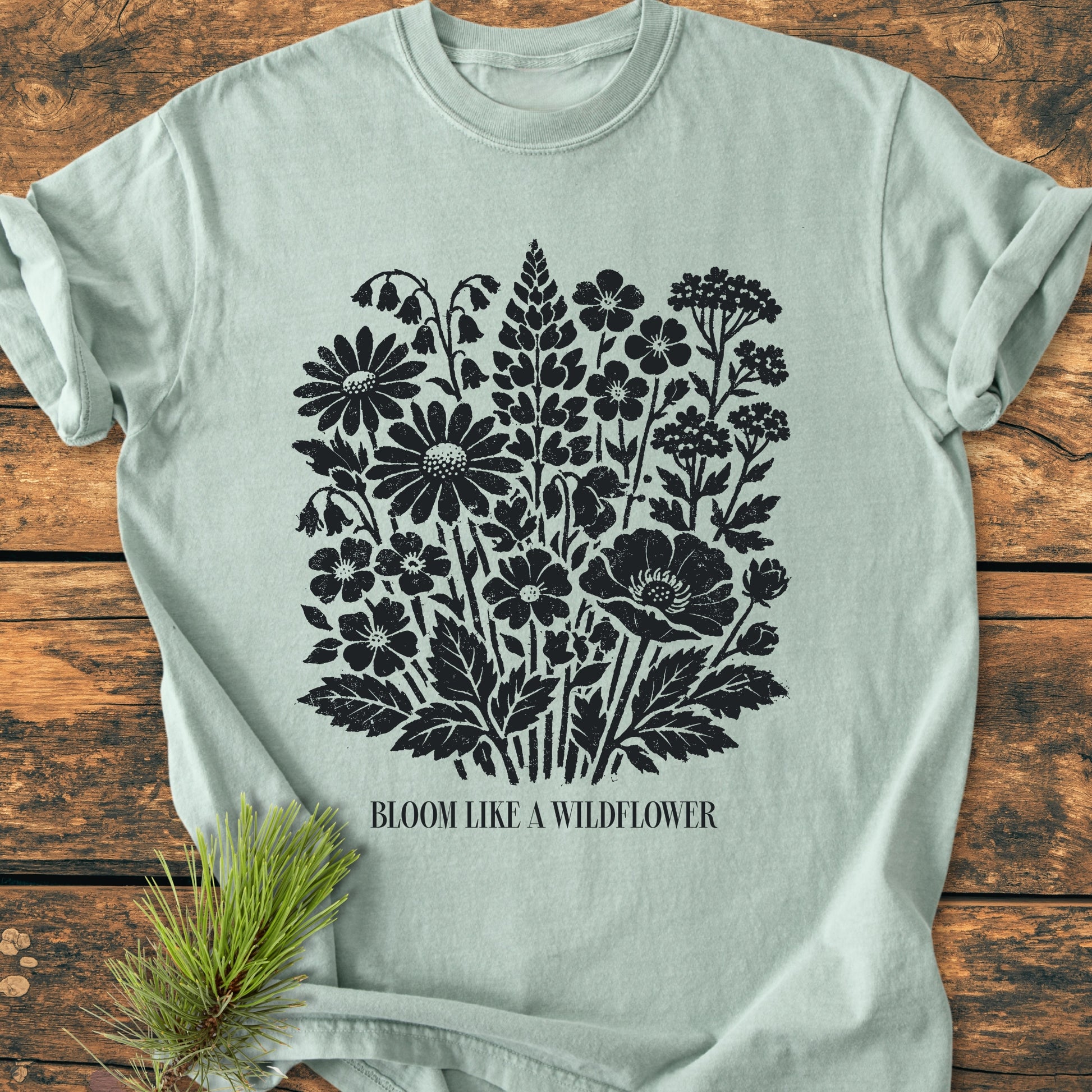 Bloom Like A Wildflower - Vintage Heavyweight Tee features a distressed wildflower bouquet graphic and BLOOM LIKE A WILDFLOWER text on a light-sage green, soft-washed, relaxed fit, 100% ring-spun cotton T-shirt.