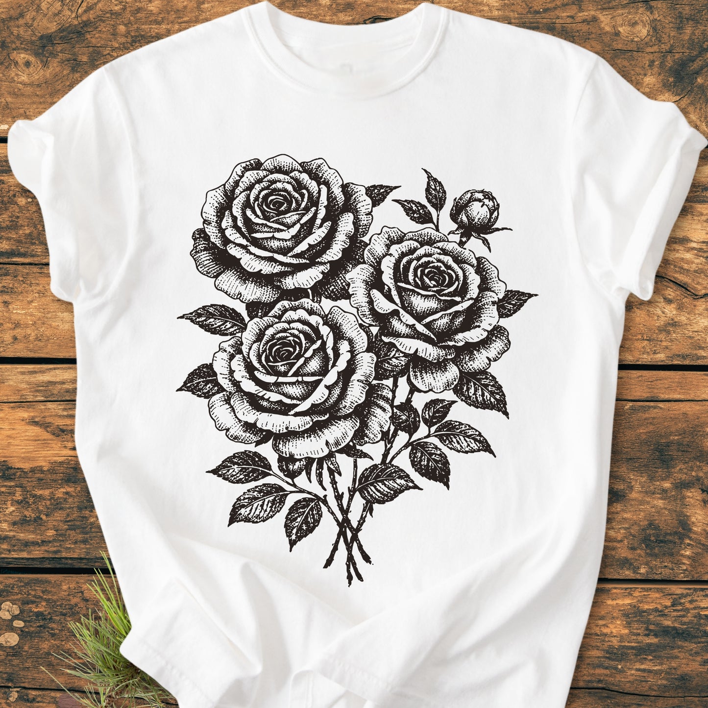 Rose Bouquet - Vintage Heavyweight Tee featuring a hand-drawn style bouquet of roses and foliage on a white T-shirt, laid on a wooden surface, highlighting its relaxed fit and durable double-needle stitching.