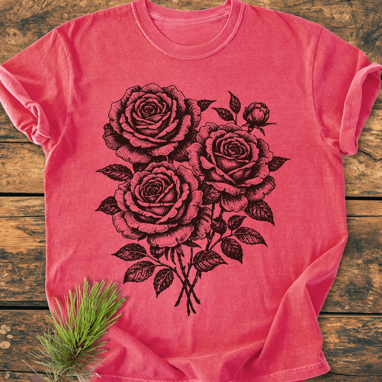 The Rose Bouquet - Vintage Heavyweight Tee features a hand-drawn rose illustration on a soft, coral-hued cotton fabric. Laid flat, it highlights the shirt's relaxed fit and rustic charm.