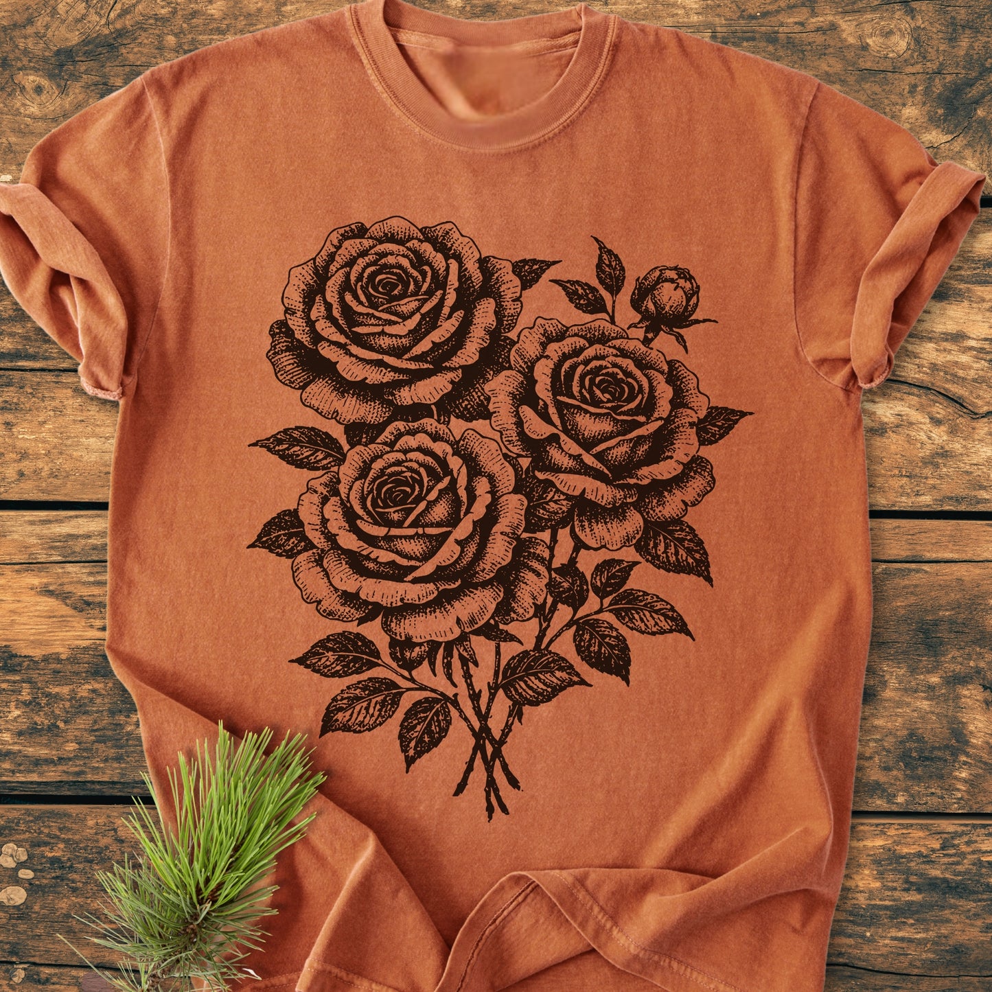 Rose Bouquet - Vintage Heavyweight Tee featuring a black hand-drawn rose bouquet print, laid on weathered wood with a pine branch. Crafted from soft, durable ring-spun cotton, offering a relaxed fit.