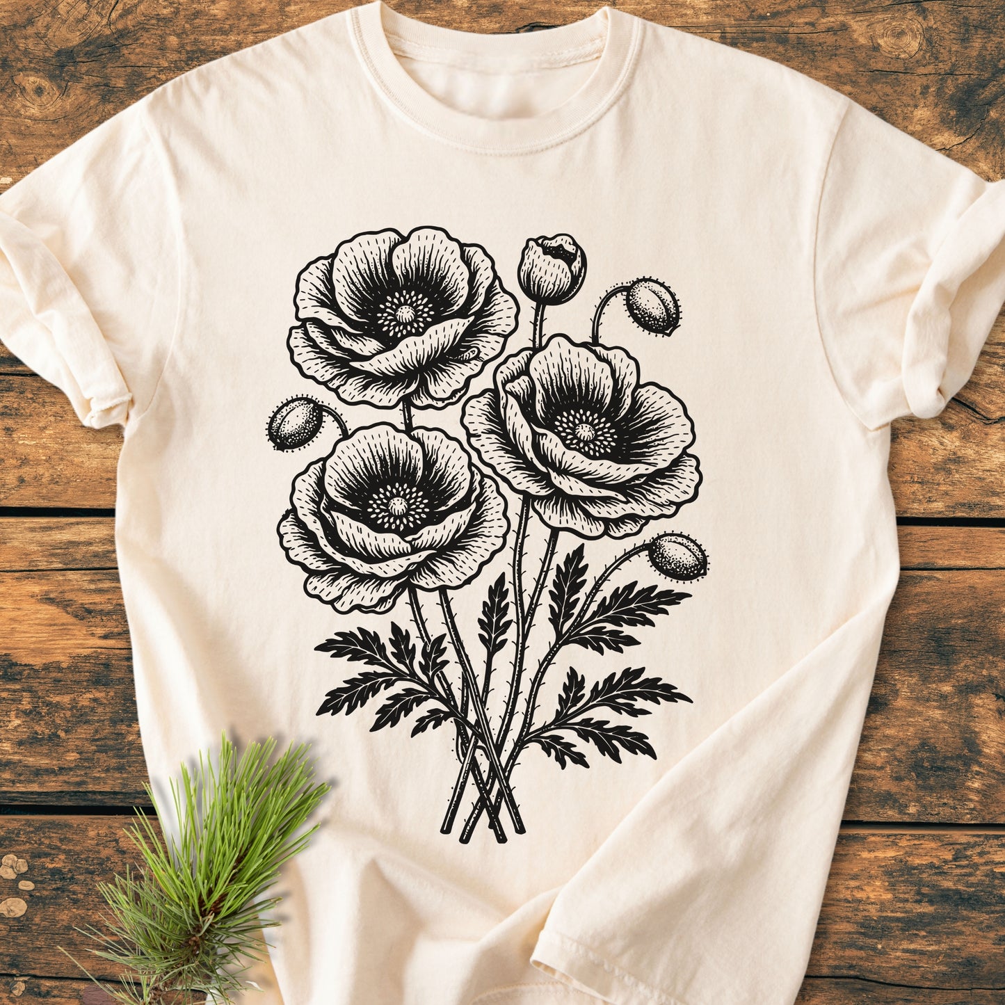Poppy Bouquet - Vintage Heavyweight Tee laid flat, showcasing black poppy line-art on cream fabric. Rustic wooden surface complements the relaxed, soft-washed design, highlighting its comfort and durability.