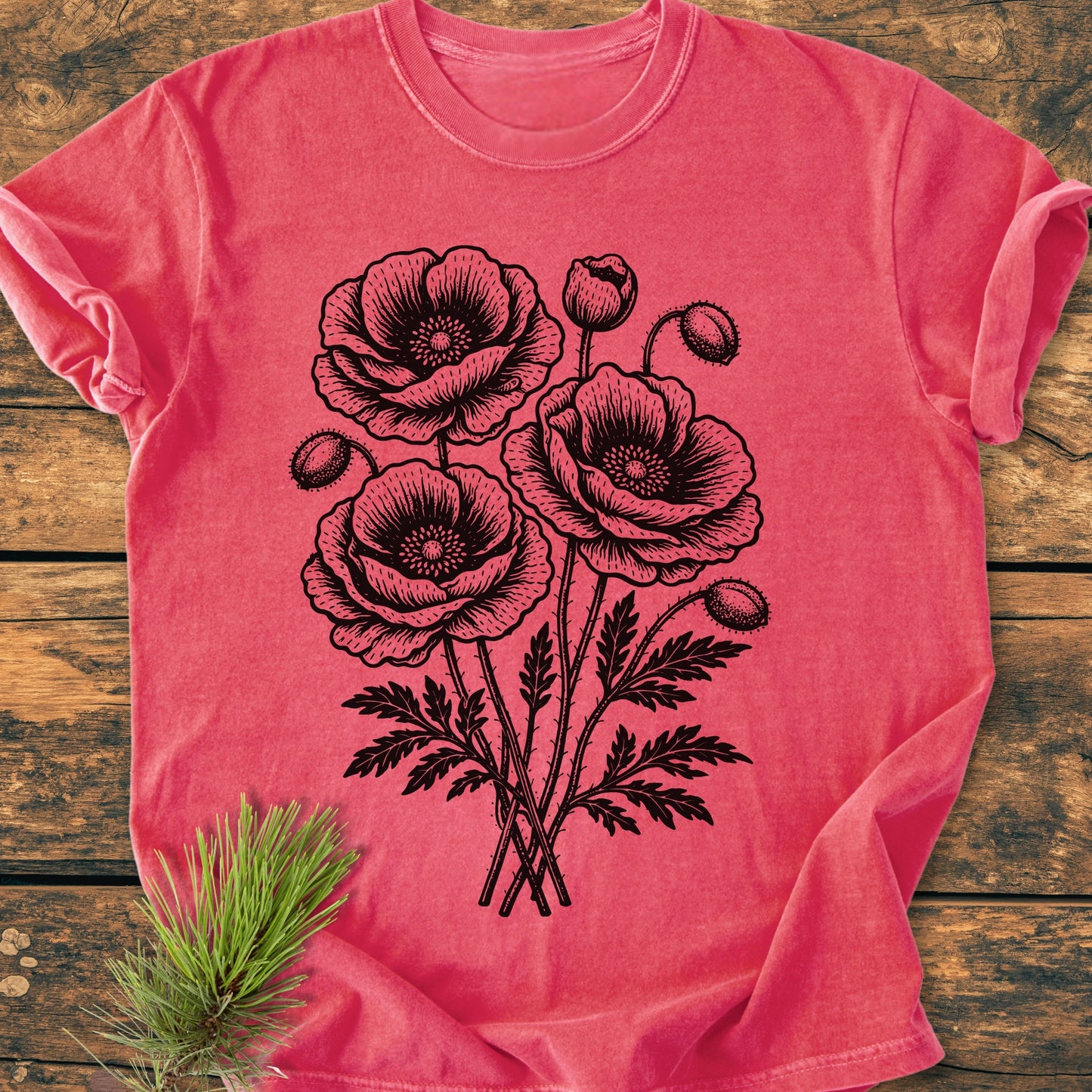 Poppy Bouquet - Vintage Heavyweight Tee features a bold black line-drawing of poppy blooms on a coral-red background, laid flat on a rustic surface, showcasing its relaxed fit and durable design.