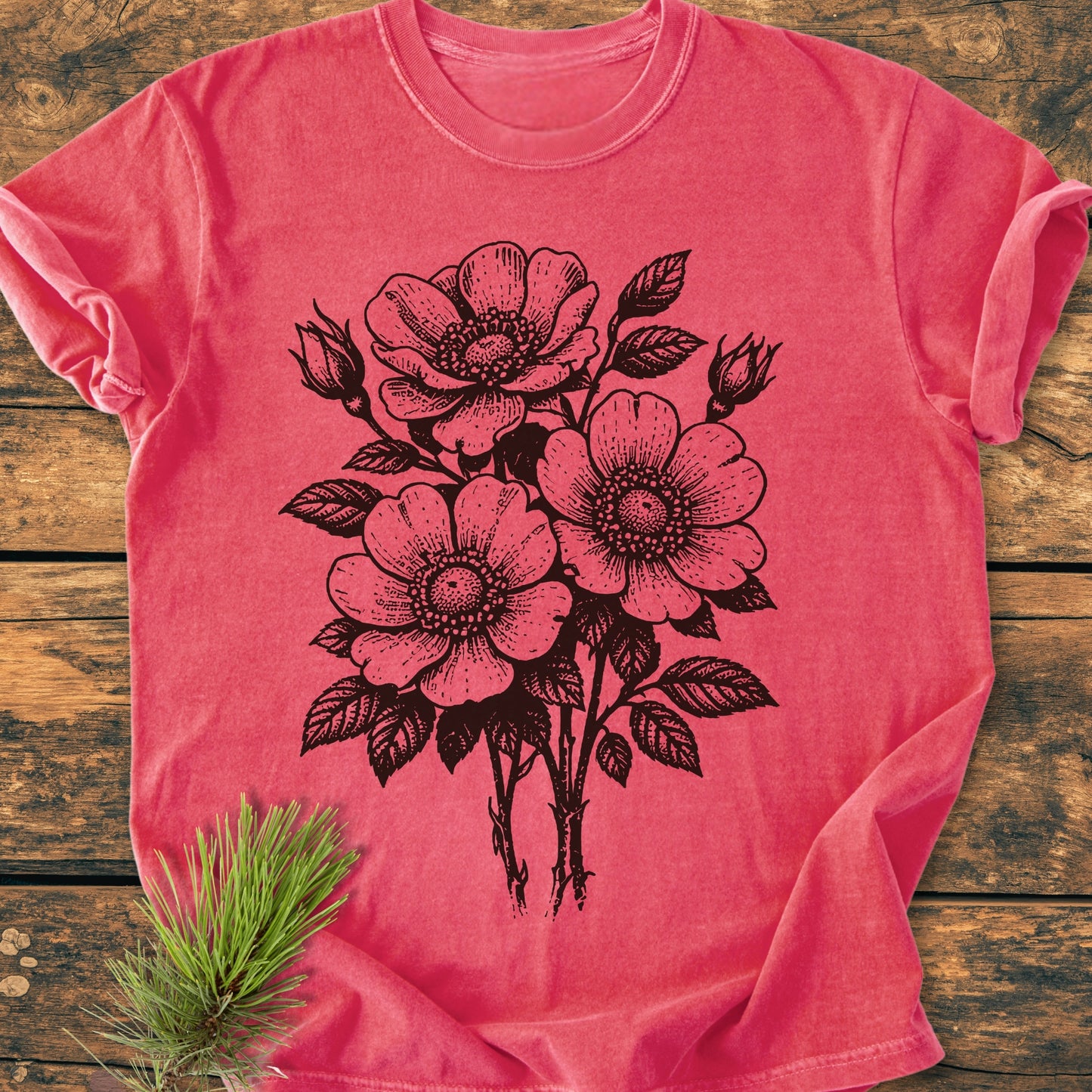 Wild Rose Bouquet - Vintage Heavyweight Tee, featuring a stylized floral design, laid on a wooden surface. The relaxed, garment-dyed t-shirt offers comfort and durability with its ring-spun cotton construction.