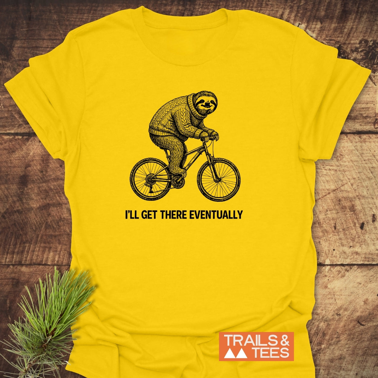 Bright yellow I'll Get There Eventually T-shirt featuring a sloth on a bicycle print, designed for outdoor enthusiasts by Trails & Tees, made from soft, lightweight, ring-spun cotton for everyday comfort.
