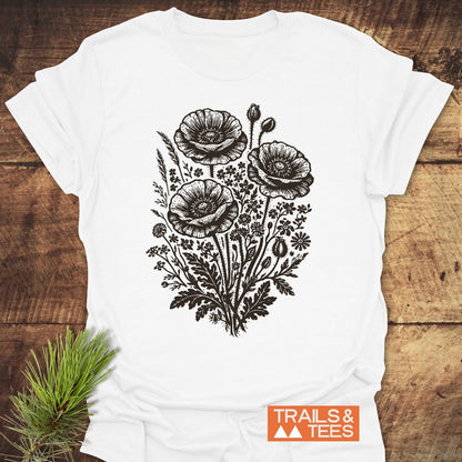 Wildflower Bouquet T-Shirt featuring a vintage-style floral line drawing centered on the chest, laid on wood. Made from soft, ring-spun cotton, designed for comfort and durability in outdoor adventures.