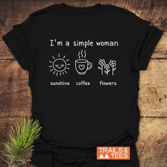 I'm A Simple Woman. Sunshine Coffee Flowers T-Shirt: Black tee with white slogan and icons of a sun, mug, and flowers, featuring a TRAILS & TEES logo, showcasing outdoor-inspired, durable comfort.