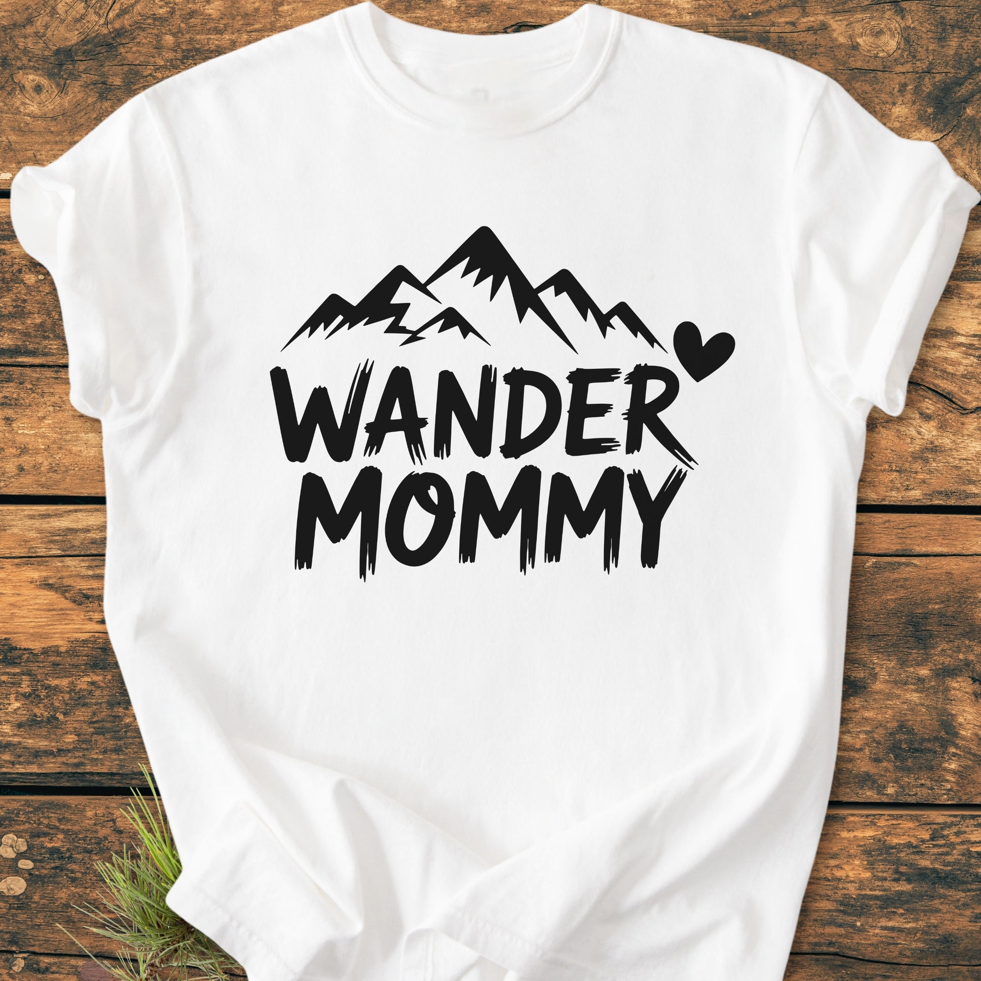 Wander Mommy - Vintage Heavyweight Tee features a mountain graphic and text on a white T-shirt, laid flat, showcasing its relaxed fit and durable stitching, perfect for everyday comfort.