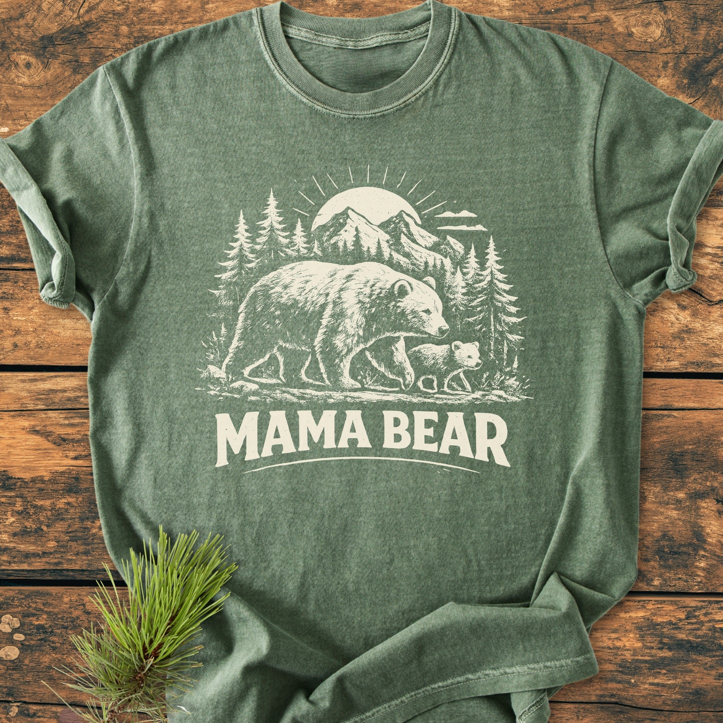 Mama Bear - Vintage Heavyweight Tee features a woodland scene with a bear and cub, printed on a heather-green T-shirt. The soft-washed, relaxed fit ensures comfort and durability.
