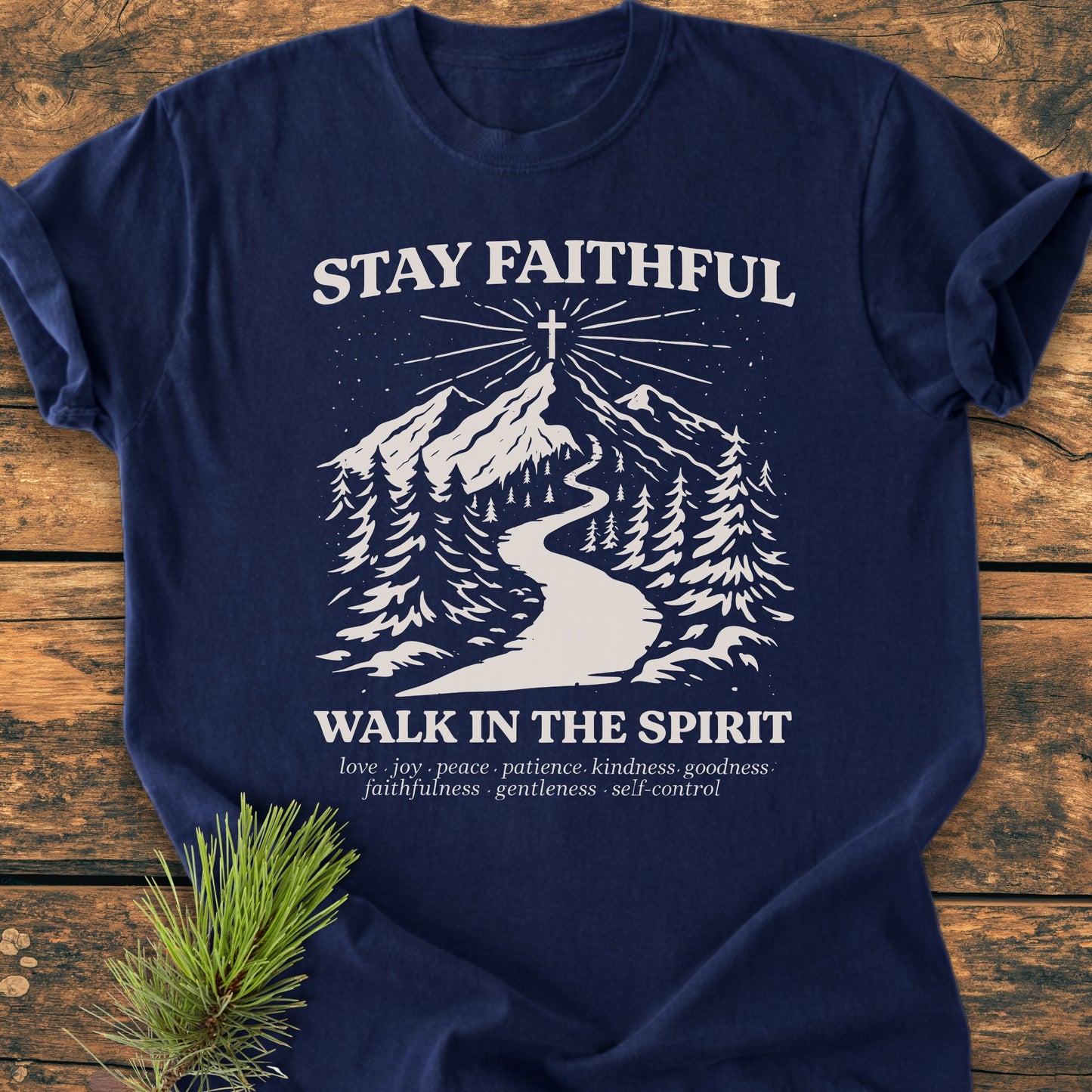 Stay Faithful - Vintage Heavyweight Tee features a mountain scene with a cross and fruit of the Spirit list, styled with a pine sprig, highlighting its durable, relaxed fit and cozy fabric.