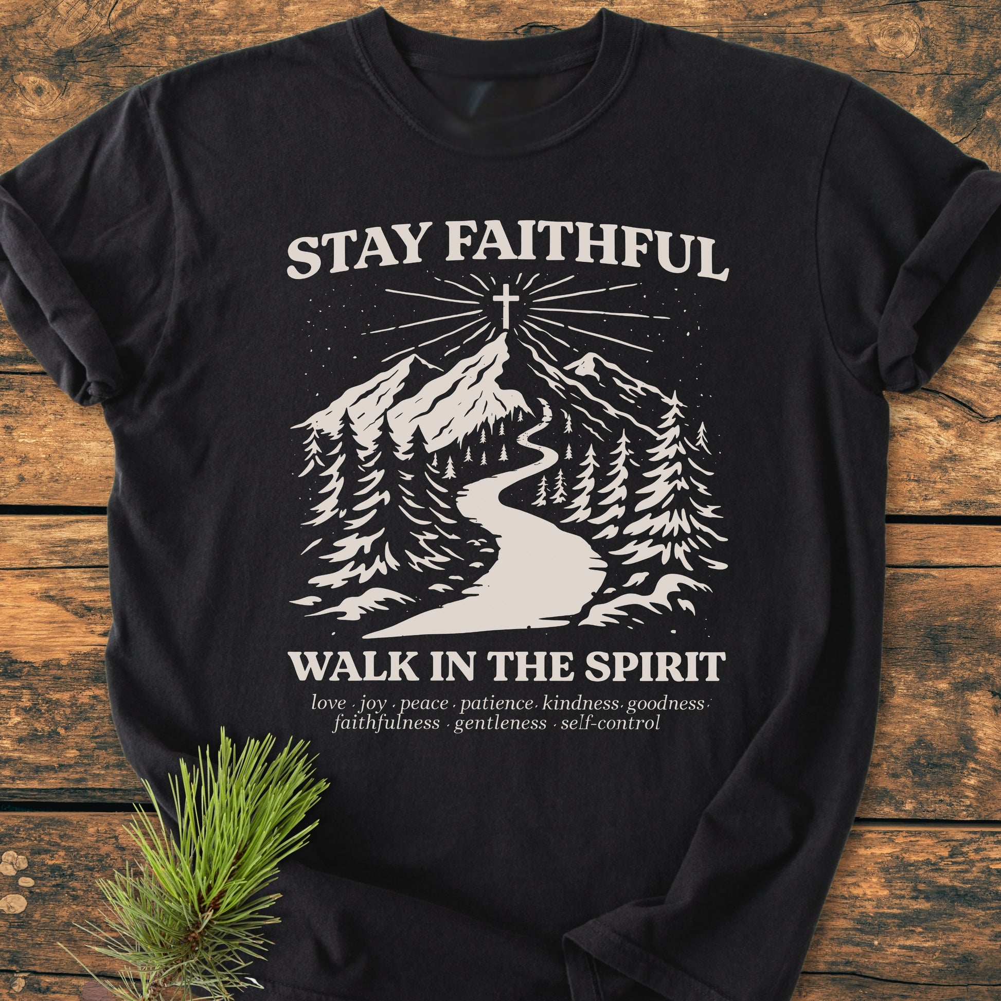 Stay Faithful - Vintage Heavyweight Tee featuring an off-white nature scene with a pine forest, mountain peak, and cross. Text includes STAY FAITHFUL and WALK IN THE SPIRIT with spiritual virtues listed below.