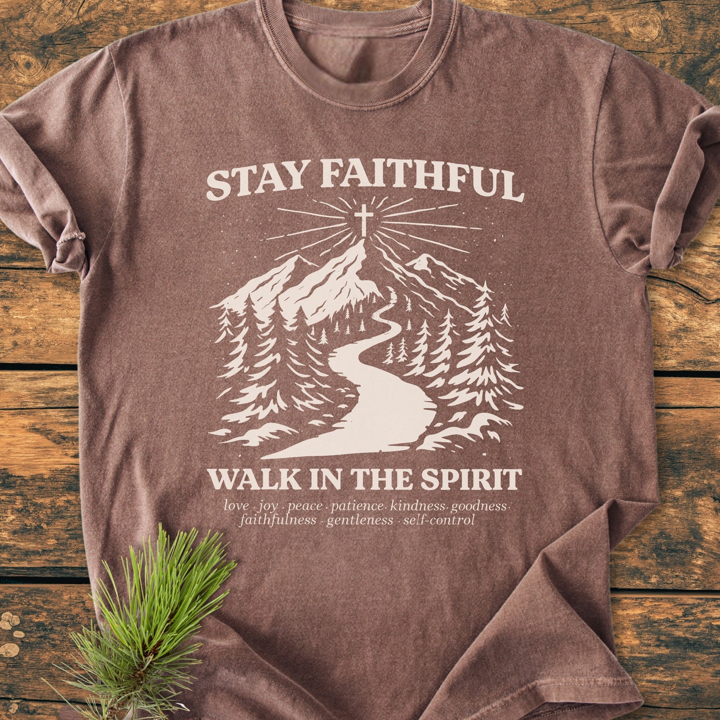 Stay Faithful - Vintage Heavyweight Tee features a stylized mountain scene with pine trees and a hilltop cross, overlaid with spiritual messages. Made from cozy, durable, 100% ring-spun cotton.