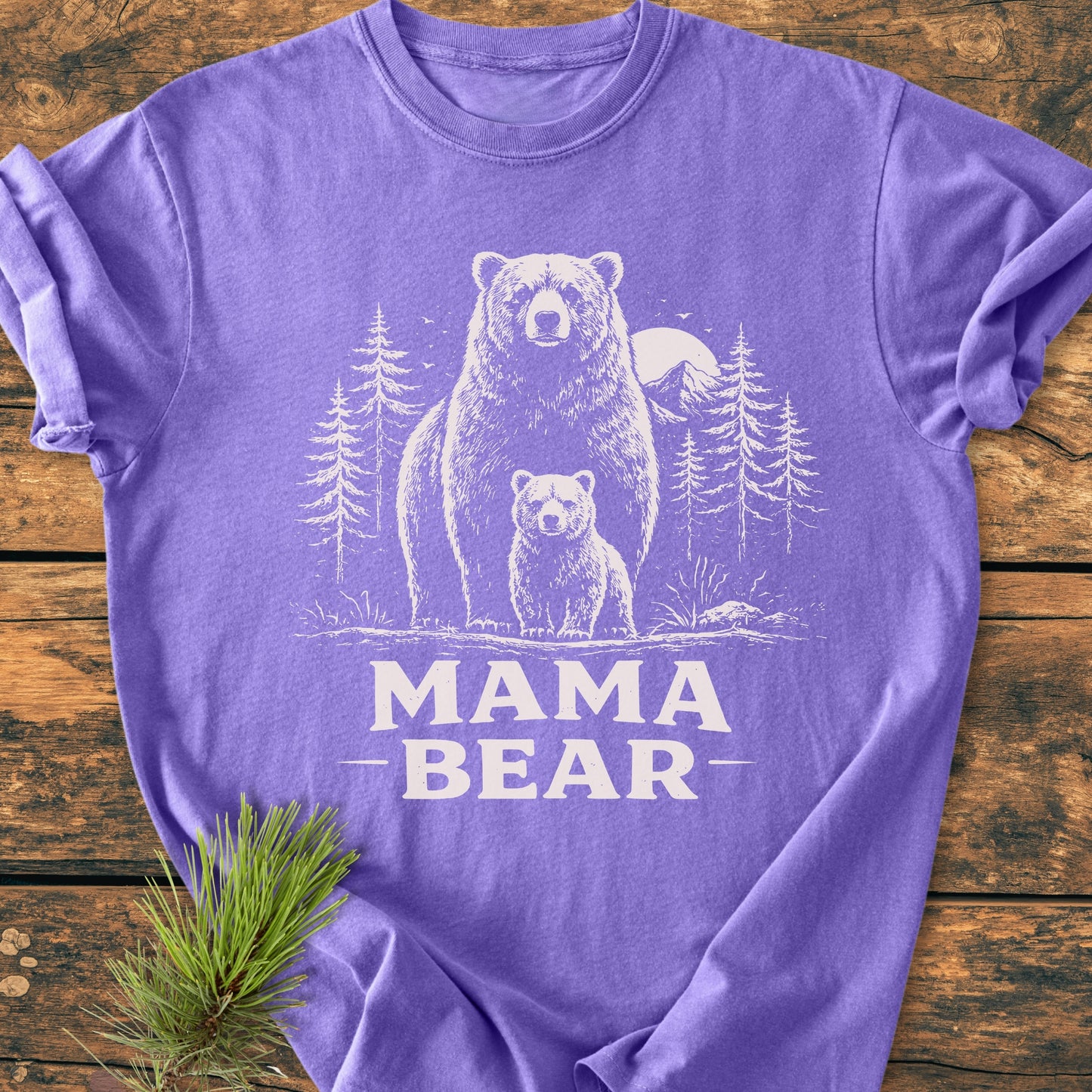 Mama Bear - Vintage Heavyweight Tee features a bear and cub illustration with MAMA BEAR text, laid on wood. Soft, durable, garment-dyed, pre-shrunk cotton for comfort and style.