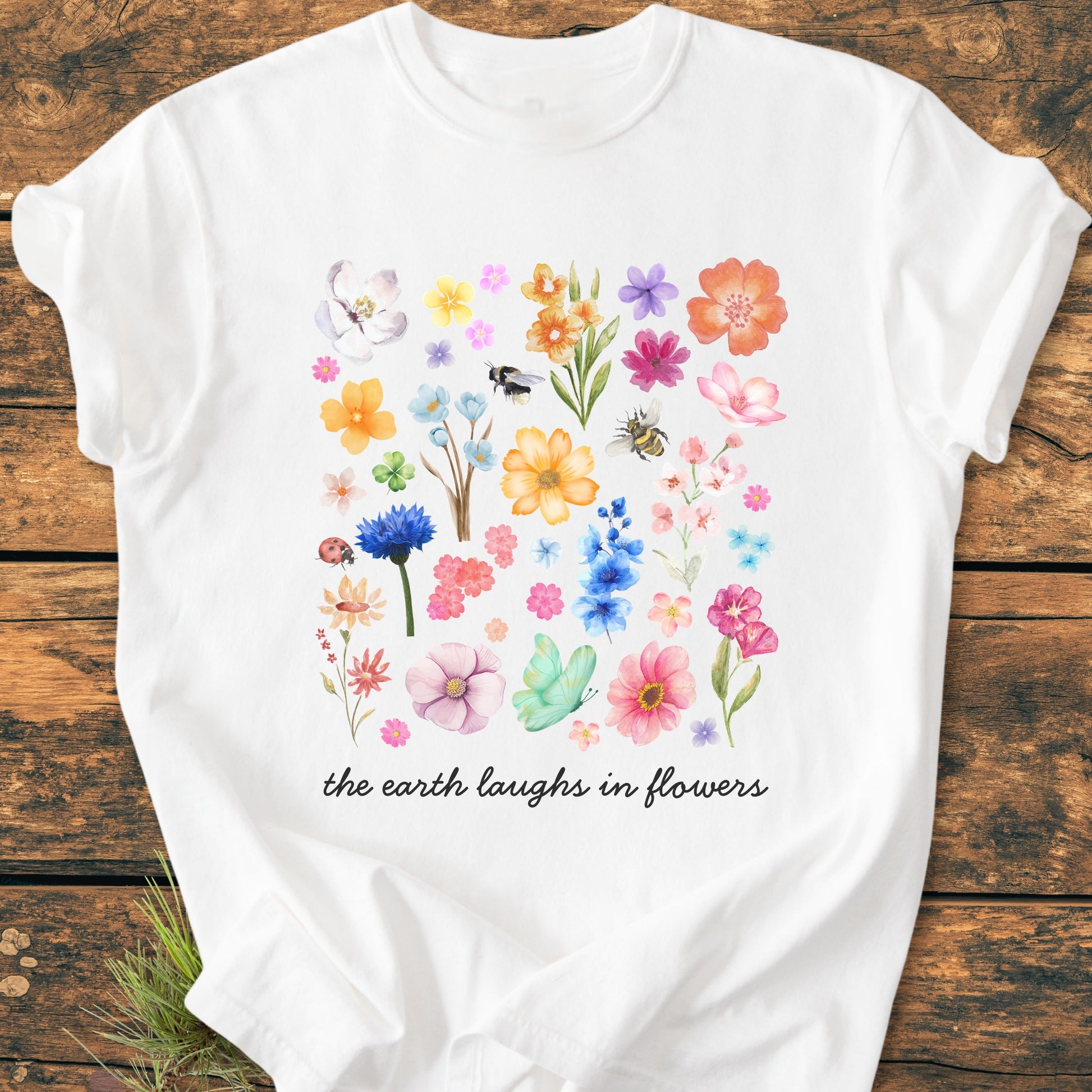 The Earth Laughs In Flowers - Vintage Heavyweight Tee features a watercolor-style floral collage with insects and the scripted phrase, adding charm to this relaxed, garment-dyed, 100% ring-spun cotton T-shirt.