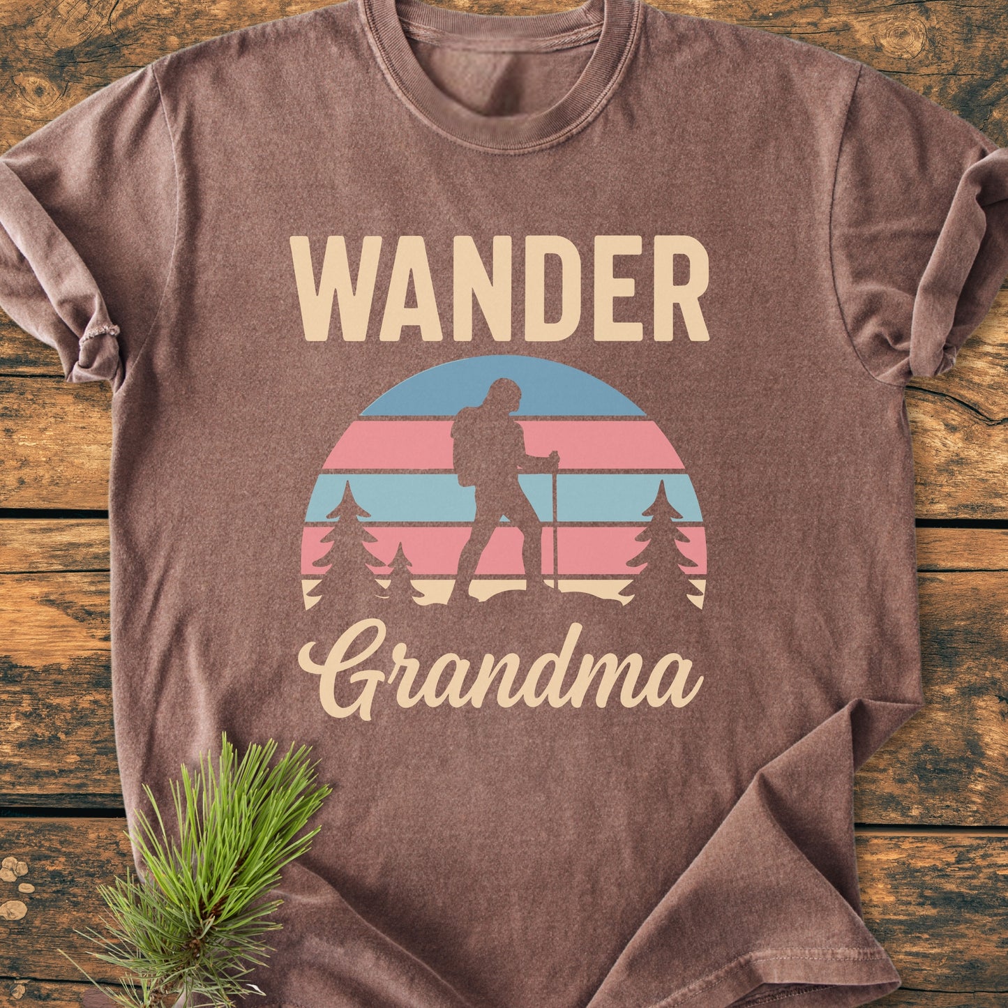 Wander Grandma - Vintage Heavyweight Tee featuring a retro graphic with WANDER and Grandma, a sunrise motif, hiker silhouette, and pine trees, on a soft brown, short-sleeved, garment-dyed T-shirt.