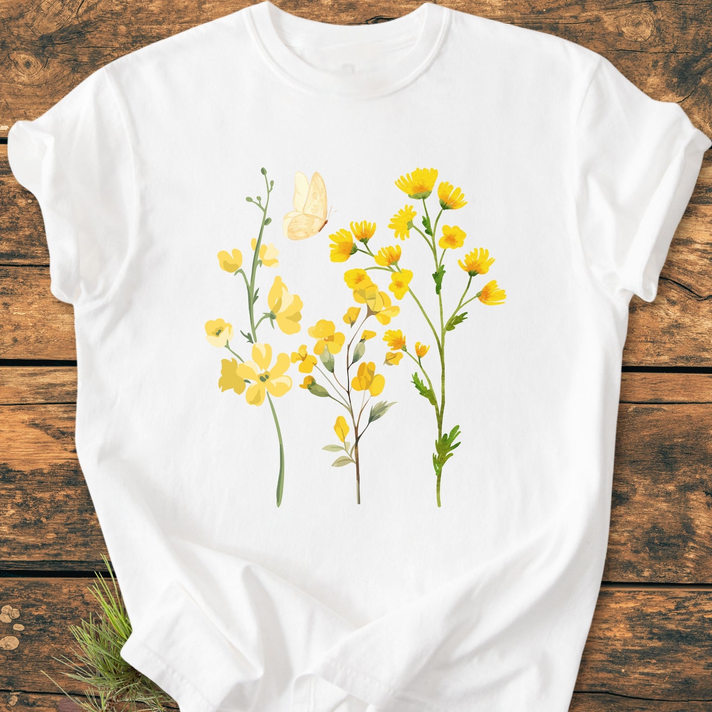 Yellow Boho Flowers - Vintage Heavyweight Tee featuring a nature-inspired graphic of yellow wildflowers and a butterfly, displayed on a wooden surface, highlighting its relaxed fit and durable craftsmanship.