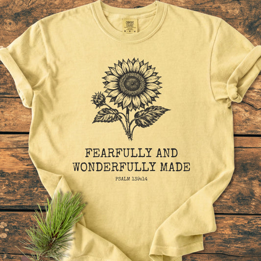 Fearfully And Wonderfully Made, Psalm 139:14 - Vintage Wash Tee featuring a black sunflower drawing and text on a pale-yellow, garment-dyed, soft-washed T-shirt, enhanced by a pine sprig accent.