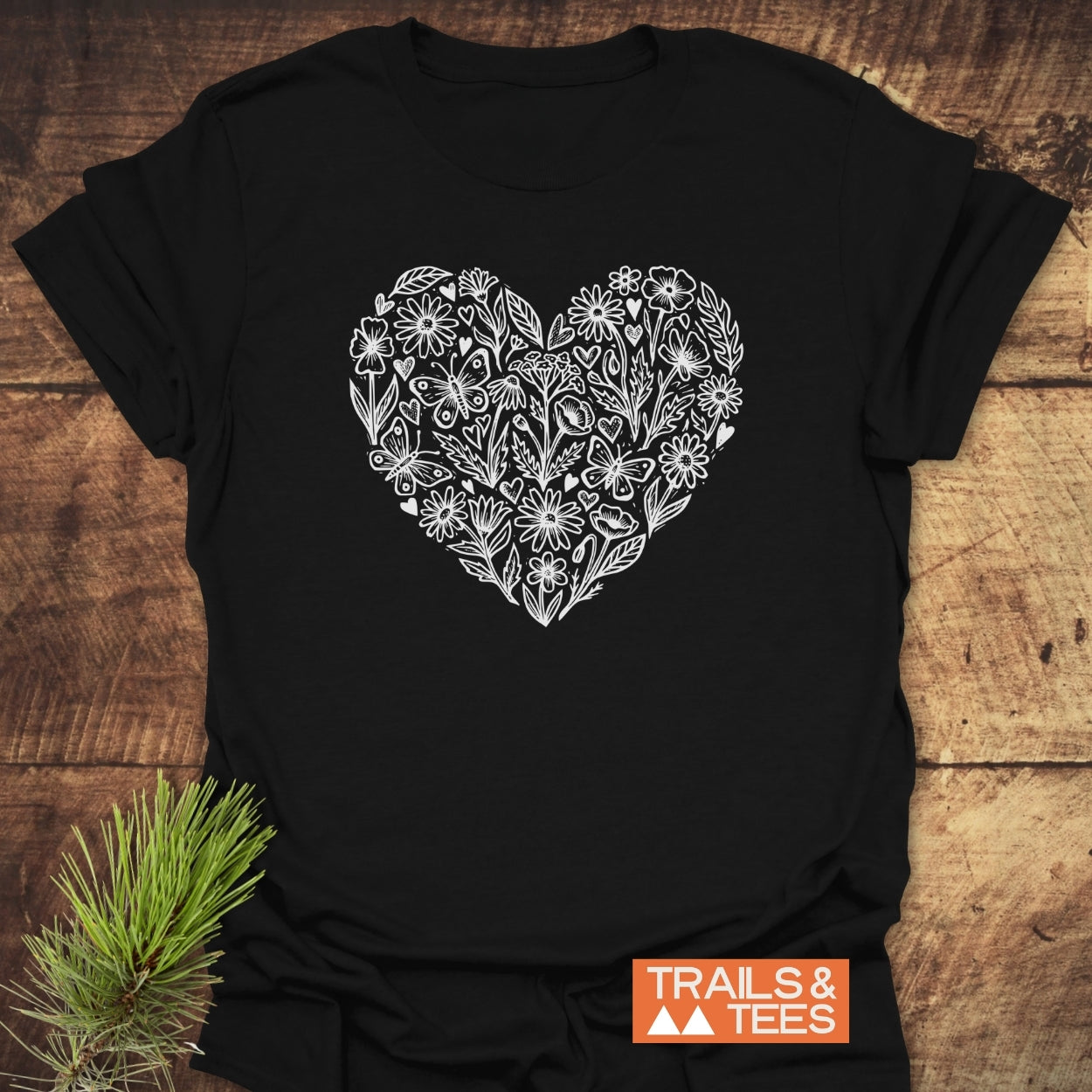 Wildflower Heart Butterfly Soul Softstyle T-Shirt featuring a white floral heart graphic on a black tee, showcasing nature-inspired artistry. Designed for comfort and durability, ideal for outdoor enthusiasts.