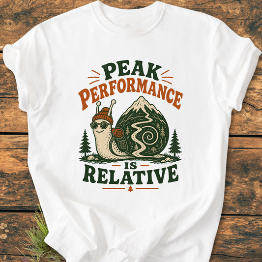 Peak Performance Is Relative - Vintage Wash Tee: White T-shirt with a cartoon snail in hiking gear on a mountain trail, featuring the slogan above and below, ideal for leisurely adventurers.