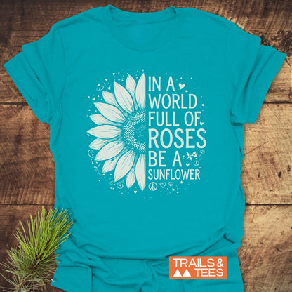 Be A Sunflower Softstyle T-Shirt features a sunflower design and uplifting phrase, ideal for nature lovers. Enhanced with doodles, it lays flat beside pine sprigs, showcasing its vibrant print and soft texture.