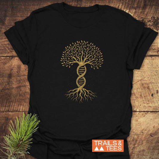 Tree Of Life T-Shirt featuring a gold stylized DNA double-helix tree print on black. Laid on wood with a pine sprig, highlighting nature-inspired design for hiking and nature enthusiasts.