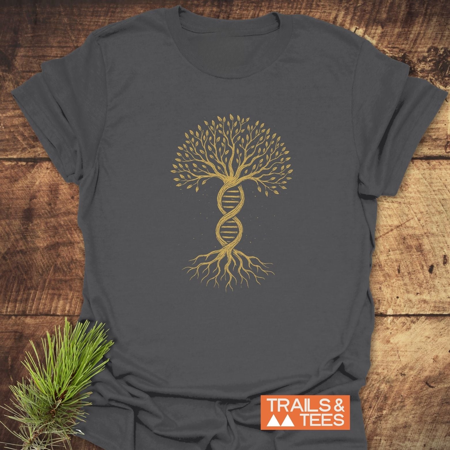 Tree Of Life T-Shirt featuring a gold “tree of life” graphic with a DNA helix trunk. Laid on wood, embodying nature's essence. Ideal for nature lovers, crafted with soft, breathable cotton.