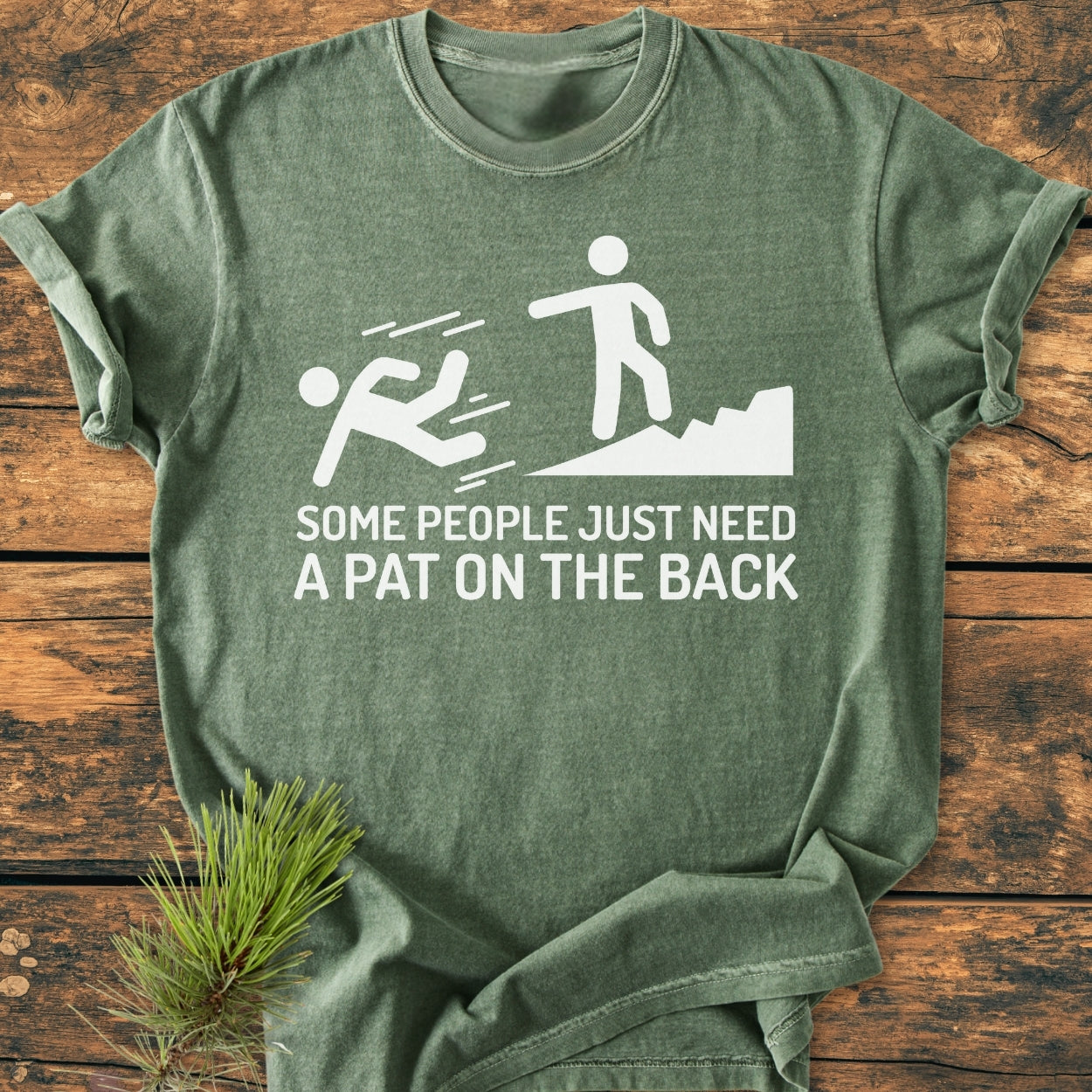 Heather-green t-shirt titled Some People Just Need A Pat On The Back - Vintage Wash Tee, featuring a humorous stick-figure graphic. Designed for hikers, it embodies adventure and comfort with a vintage feel.