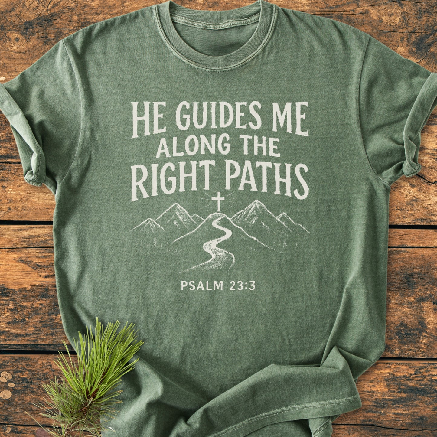 Green T-shirt with mountain scene and Psalm 23:3 quote: He guides me along the right paths. He Guides Me - Vintage Wash Tee, perfect for expressing faith and love for nature.