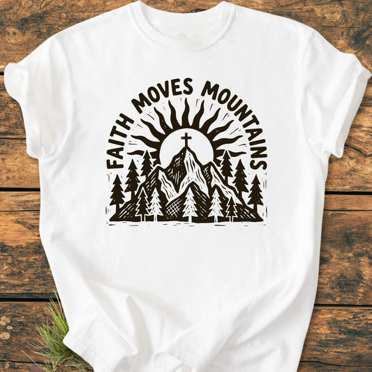 1409 Faith Moves Mountains T-shirt features a mountain scene with pine trees, a sun, and a cross on the summit, complemented by the slogan. Crafted from soft, durable, 100% ring-spun cotton.