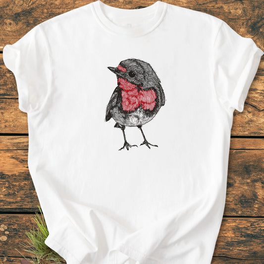 Cute Robin Tee — features a sketch-style bird with grey feathers and a red breast, printed on a soft, vintage wash white T-shirt, laid on a wooden surface for a casual, relaxed look.