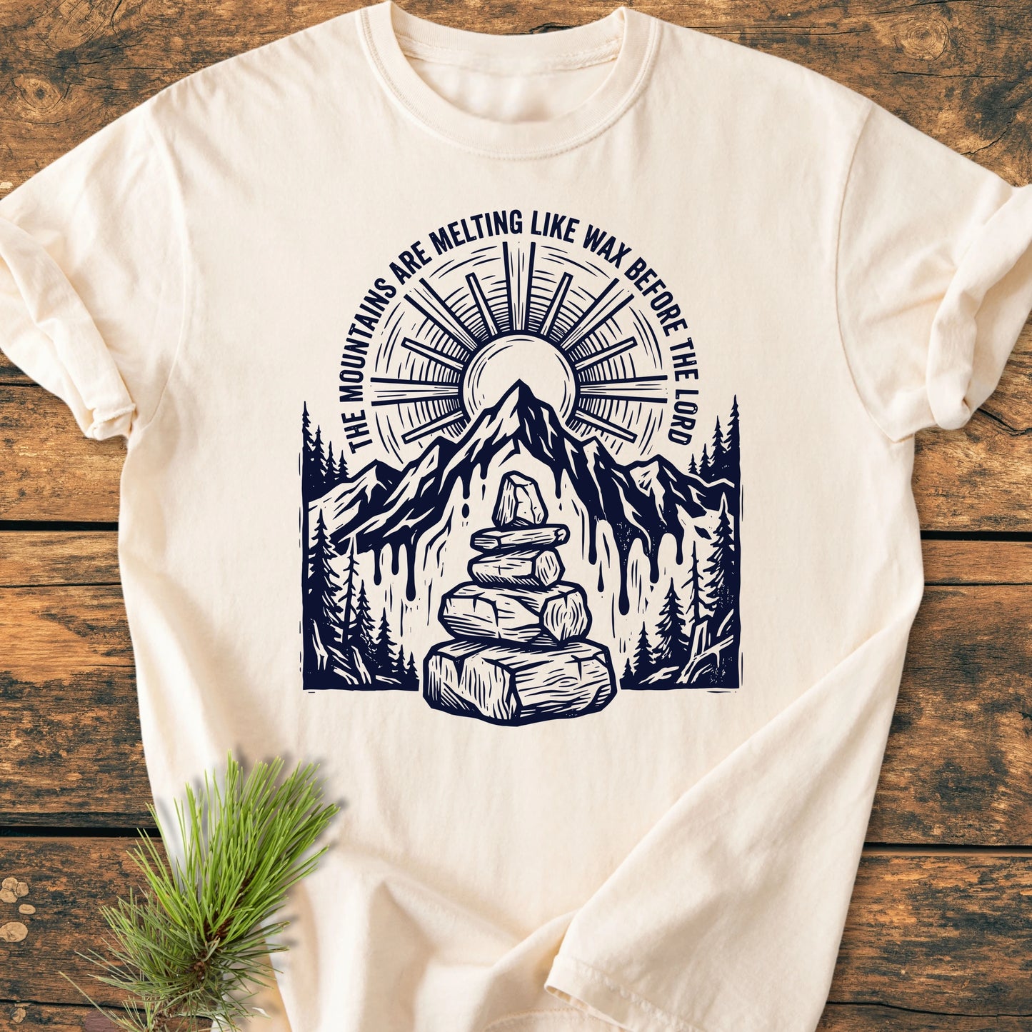 Off-white T-shirt, 1414 Mountains Melting Like Wax, showcases a stylized mountain scene with melting sides, sun, pine trees, and cairn, enhancing its vintage wash character and relaxed fit.