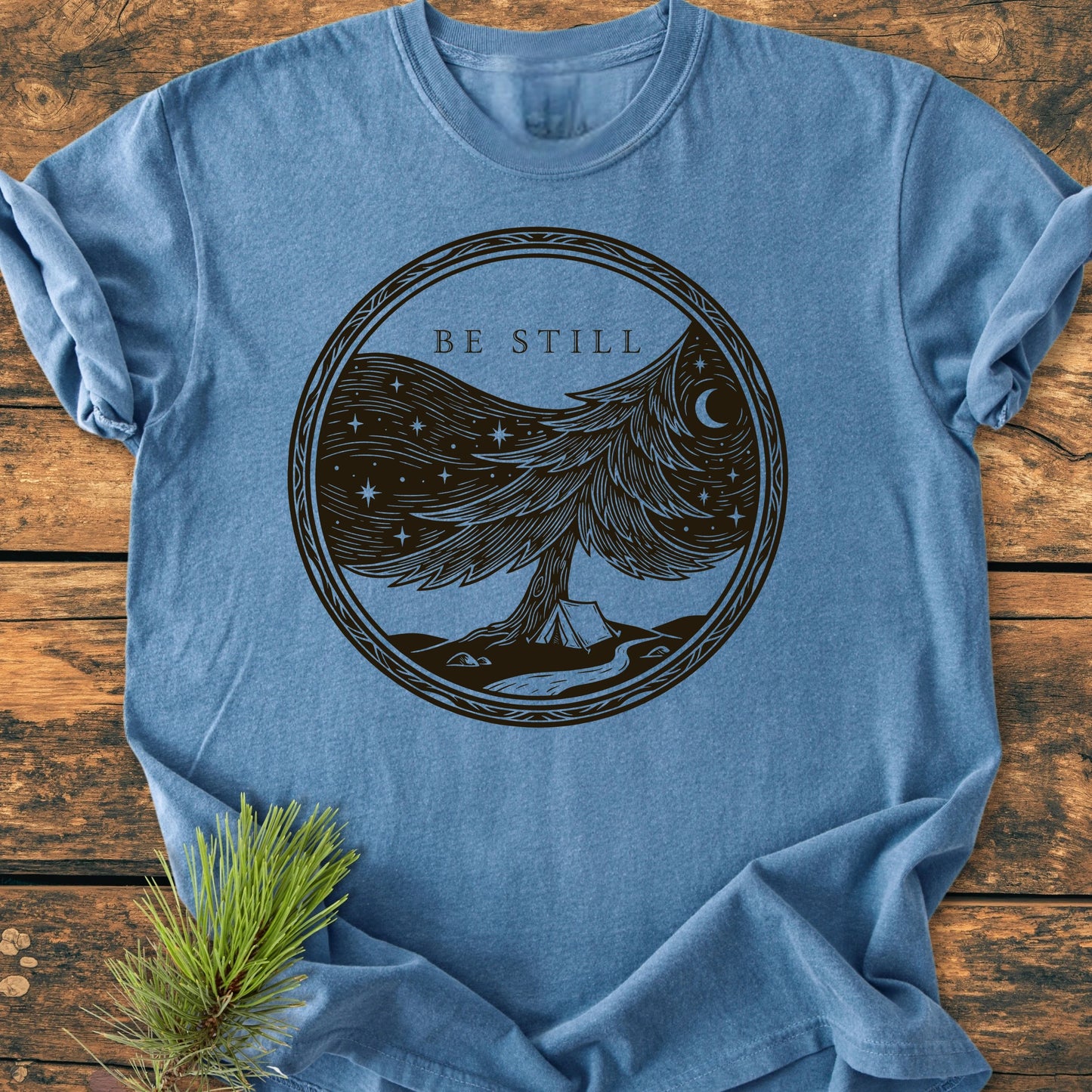 Heather-blue 1411 Be Still T-shirt featuring a serene hand-drawn tree design with a night sky, crescent moon, camping tent, and stream, on soft, relaxed-fit, garment-dyed cotton.