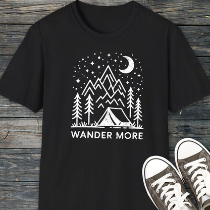 Wander More T-Shirt featuring a hand-drawn camping scene with a tent, trees, and mountains, highlighting outdoor adventure. Paired with canvas sneakers for a complete look.