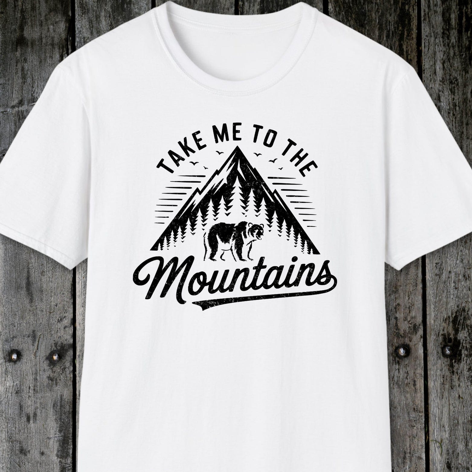 Take Me To The Mountains T-Shirt with a mountain and bear graphic, designed for comfort and adventure, featuring durable prints and a unisex fit.