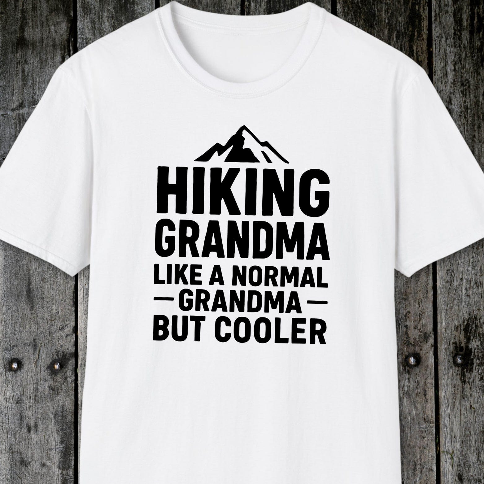 White T-shirt featuring a mountain graphic and Hiking Grandma text, crafted from soft cotton for comfort, designed for outdoor enthusiasts.