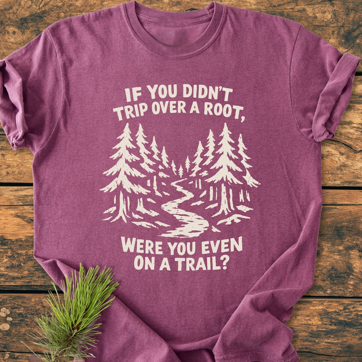 Were You Even On A Trail? - Vintage Wash Tee features a stylized forest scene and slogan on a soft, relaxed-fit, heathered-purple T-shirt, laid on wood with a pine bough accent.