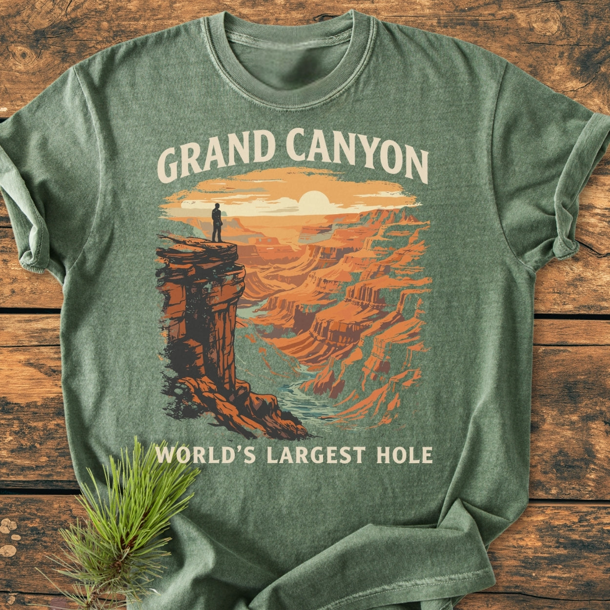 Heather-green Grand Canyon Large Hole - Vintage Wash Tee with a vintage Grand Canyon sunrise graphic, laid flat on wood, featuring durable, soft-washed cotton fabric, relaxed fit, double-needle stitching, and no side seams.