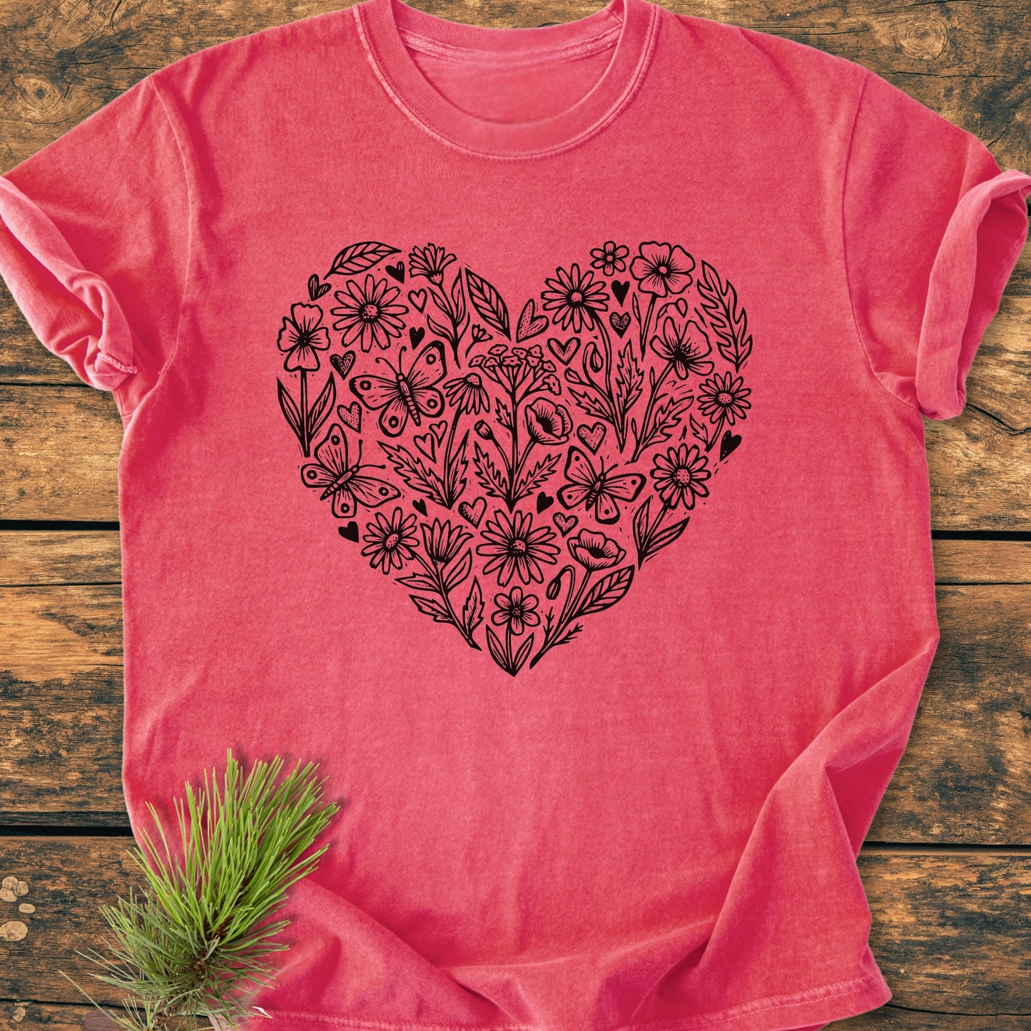 Wildflower Heart Butterfly Soul - Vintage Heavyweight Tee in faded-coral, features a large black heart graphic filled with flowers and butterflies, displayed flat on wood, highlighting its relaxed fit and durable stitching.