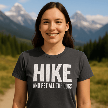 Young woman wears a Hike And Pet Dogs T-Shirt in a mountainous area, showcasing its soft cotton fit and durable print for outdoor enthusiasts.