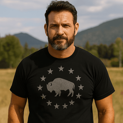 Man outdoors wearing the Born to Roam – Vintage Bison T-Shirt, featuring a stylized buffalo silhouette and stars, crafted from soft, lightweight cotton for everyday adventures.