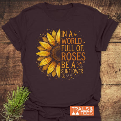 Be A Sunflower Softstyle T-Shirt featuring a half-sunflower graphic with hearts and peace signs, against a rustic backdrop, capturing warmth and individuality, perfect for nature lovers and positive souls.