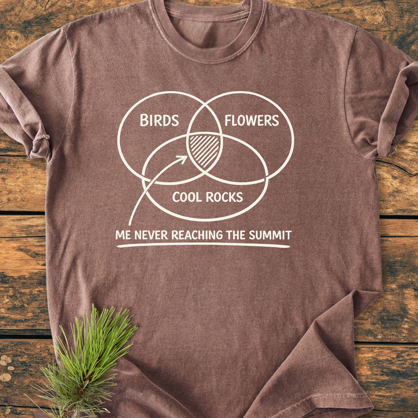 The 1416 Easily Distracted Hiker tee features a white Venn diagram with Birds, Flowers, and Cool Rocks on a brown T-shirt, highlighting a humorous caption about never reaching the summit.
