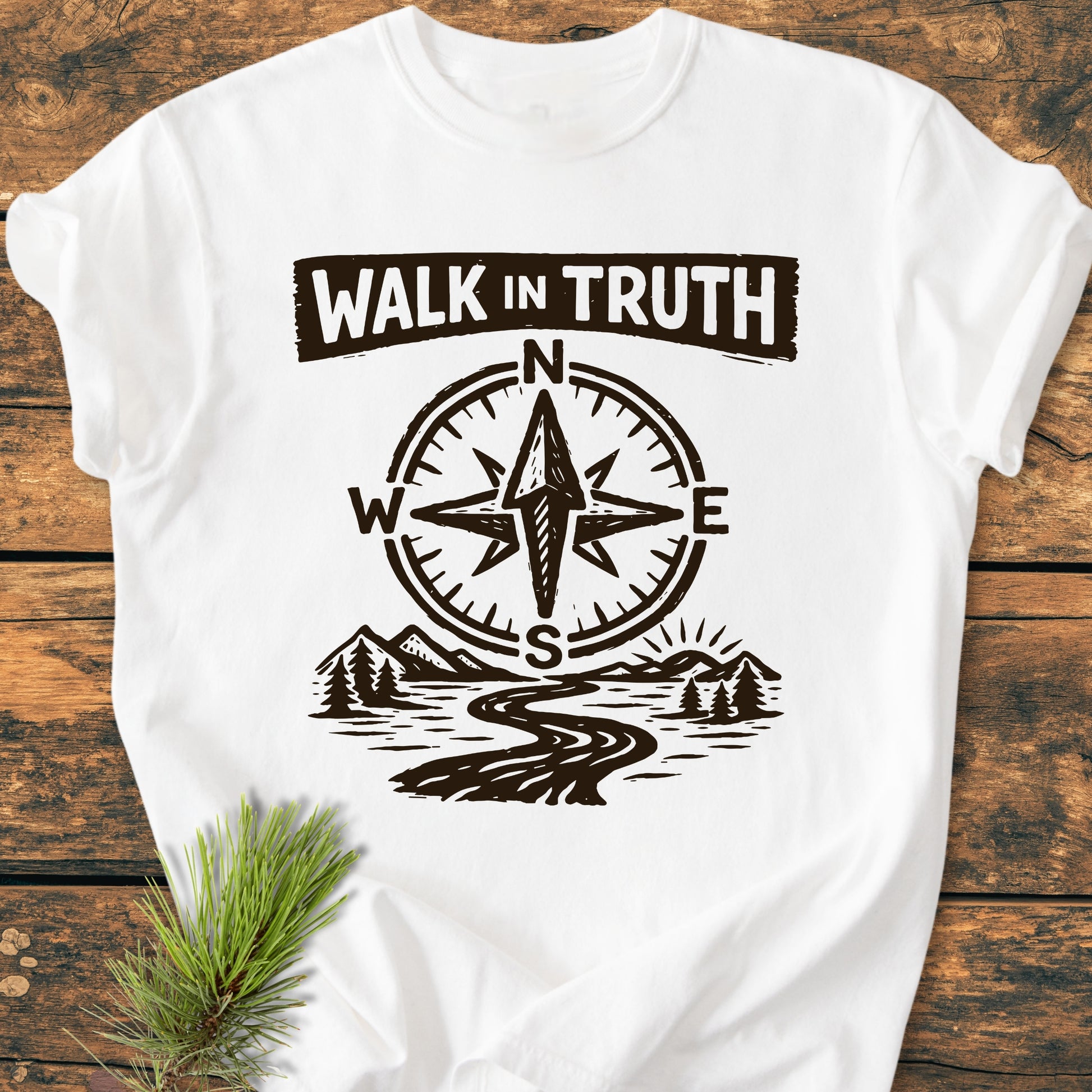 Walk In Truth 3 John 1,4 - Vintage Wash Tee features a compass rose and scenic landscape design, laid on wood with a pine sprig, showcasing its durable, relaxed-fit, garment-dyed cotton fabric.