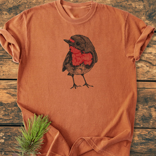 Cute Robin T-shirt on rustic wood, featuring a hand-drawn songbird with a red breast. Vintage wash, garment-dyed for softness, relaxed unisex fit. Perfect for nature enthusiasts and everyday comfort.