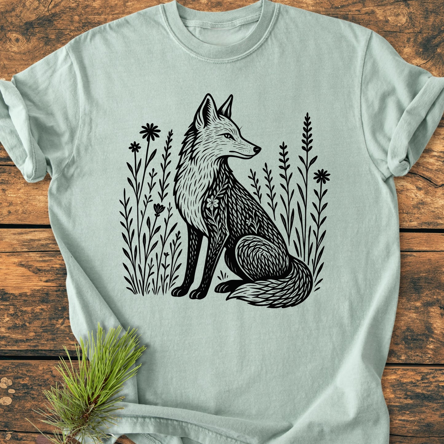 225 Wildflower Fox DARK T-shirt featuring a serene fox illustration among wildflowers, styled with a pine sprig. This soft, durable, garment-dyed tee offers a relaxed fit and tubular shape.